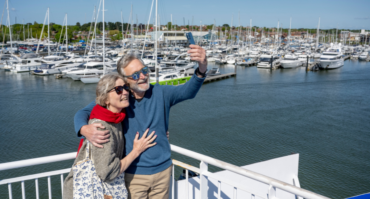 Couple stood on the ferry deck taking a selfie